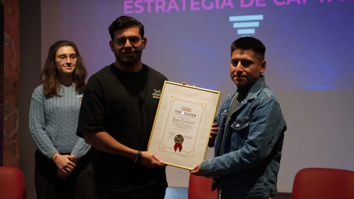 Entrega de un reconocimiento Top Master sobre el escenario